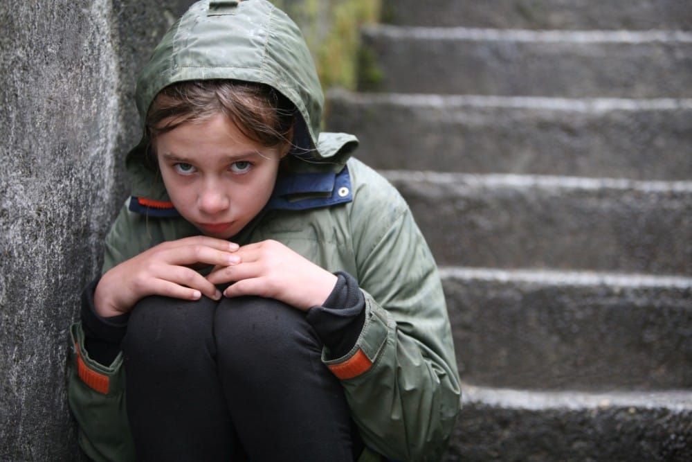 A girl sitting on steps who looks sad