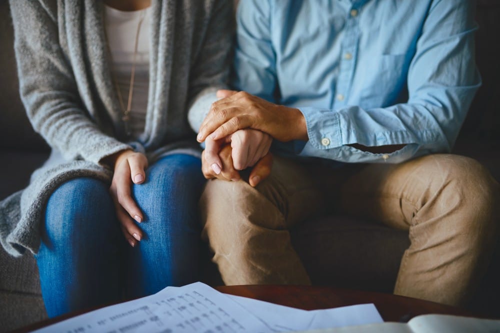 A couple sitting and holding hands
